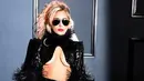Bukan Lady Gaga kalau tak tampil dengan kostum unik. Di Grammy Awards 2017 kemarin, Gaga hadir dengan kostum berdominan warna hitam dengan aksen bulu-bulu dan kaca mata hitamnya. Terlebih pada bagian dada yang terbuka, Gaga tampak seksi. (AFP/Bintang.com)