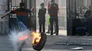Pengunjuk rasa Palestina menendang ban terbakar dalam saat bentrokan dengan pasukan keamanan Israel di pintu masuk utama kota Bethlehem, Yerusalem (25/12/2015). (AFP Photo/Musa Al-Shaer)