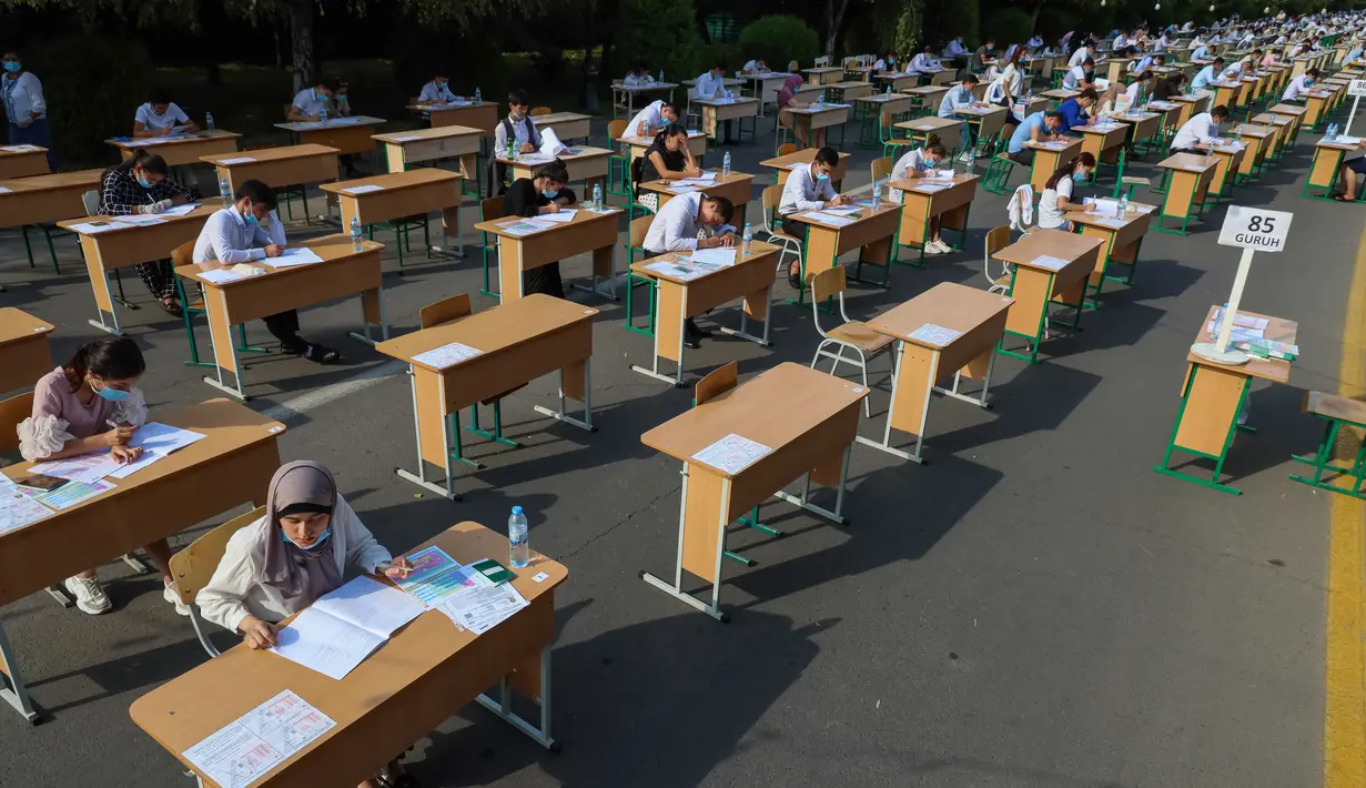 Para siswa Uzbekistan mengikuti ujian masuk luar ruangan, di tengah pandemi COVID-19 yang sedang melanda, di Tashkent pada Rabu (2/9/2020). (Photo by Yuri KORSUNTSEV / AFP)
