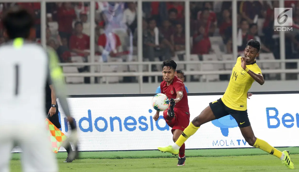 Gelandang Timnas Indonesia, Andik Vermansyah (tengah) berebut bola dengan gelandang Malaysia, M Syamer Kutty pada laga perdana Grup G Penyisihan Kualifikasi Piala Dunia 2022 zona Asia di Stadion GBK, Jakarta, Kamis (5/9/2019). Indonesia kalah 2-3. (Liputan6.com/Helmi Fithriansyah)