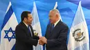 Presiden Guatemala Jimmy Morales (kiri) berjabat tangan dengan PM Israel Benjamin Netanyahu di Yerusalem, Rabu (16/5). Guatemala menjadi negara kedua yang membuka Kedubesnya di Yerusalem setelah AS. (Debbie Hill/Pool Photo via AP)