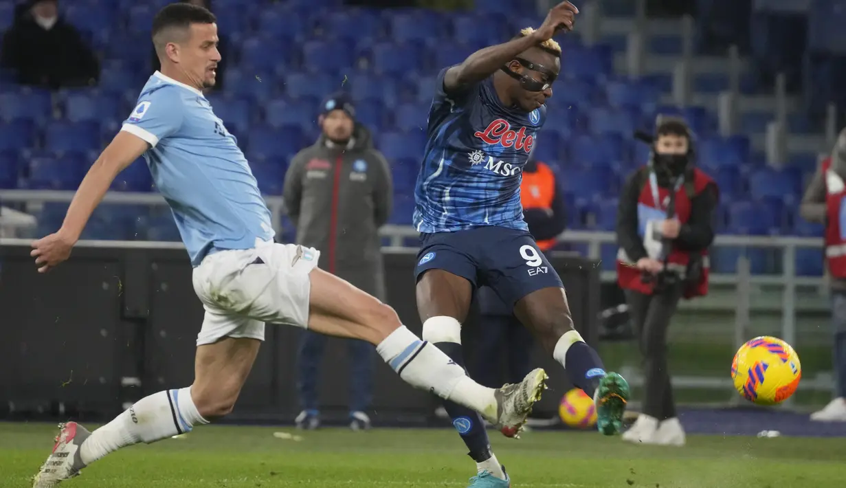 Penyerang Napoli, Victor Osimhen (kanan) berusaha menembak bola dari kawalan bek Lazio, Luiz Felipe pada pertandingan Liga Serie A Italia di stadion Olimpiade Roma, Senin (28/2/2022). Dengan kemenangan ini, Napoli berhasil memuncaki klasemen sementara dengan 57 poin. (AP Photo/Gregorio Borgia)