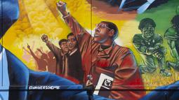 Seorang wanita melewati mural Sonhos de Liberdade karya seniman Acme, yang menghormati para pemimpin perjuangan untuk kesetaraan ras, di distrik seni Porto di Rio de Janeiro, 17 November 2021. Brasil menyambut Hari Kesadaran Kulit Hitam yang diperingati setiap 20 November. (AP Photo/Bruna Prado)