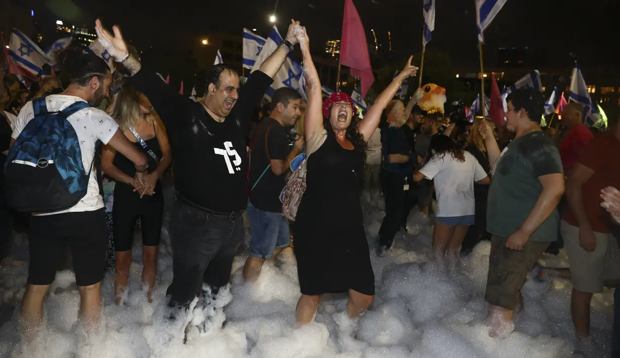 Warga Israel merayakan pelantikan pemerintahan baru di Tel Aviv, Israel, Minggu (13/6/2021). Parlemen Israel telah memberikan suara mendukung pemerintahan koalisi baru yang secara resmi mengakhiri 12 tahun pemerintahan bersejarah Perdana Menteri Benjamin Netanyahu. (AP Photo/Oded Balilty)