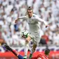 Pemain depan Real Madrid, Gareth Bale melompati bek Atletico Madrid Lucas Hernandez saat pertandingan La Liga Spanyol di stadion Santiago Bernabeu di Madrid (8/4). (AFP/Gabriel Bouys)