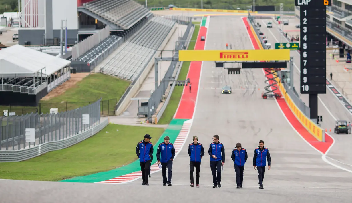 Pembalap Indonesia dari tim Scuderia Toro Rosso, Sean Geleal (kiri) berjalan selama pratinjau jelang Grand Prix F1 AS di Circuit of The Americas, Austin (18/10). Tahun lalu pembalap kelahiran Jakarta ini sudah beberapa kali ikut FP1. (AFP Photo/Peter Fox)
