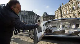 Seorang warga mengambil gambar interior  dari Mercedes Benz F 015 saat dipamerkan di Dam Square, Amsterdam, Belanda, Minggu (13/3/2016). Bentuknya yang unik dan futuristik membuat kehadirannya menjadi pusat perhatian warga Amsterdam. (AFP Photo/Bart Maat)