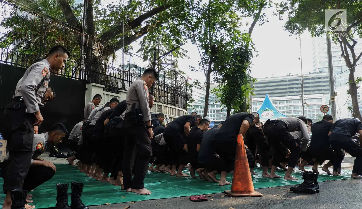 Pasukan Brimob menunaikan ibadah salat Ashar berjamaah disela pengamanan di kawasan Bundaran HI, Jakarta, Rabu (29/5/2019). Di tengah tugas mengamankan situasi, para anggota Brimob tak lupa untuk tetap menjalankan kewajibannya sebagai umat beragama. (Liputan6.com/Faizal Fanani)