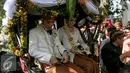 Pasangan pengantin Gibran-Selvi saat berada di kereta kuda usai resepsi pernikahannya dan akan menuju kediaman Gibran di Jalan Kutai Utara RT.08/RW.07 Sumber, Solo, Jateng, Kamis (11/6/2015). (Liputan6.com/Faizal Fanani)
