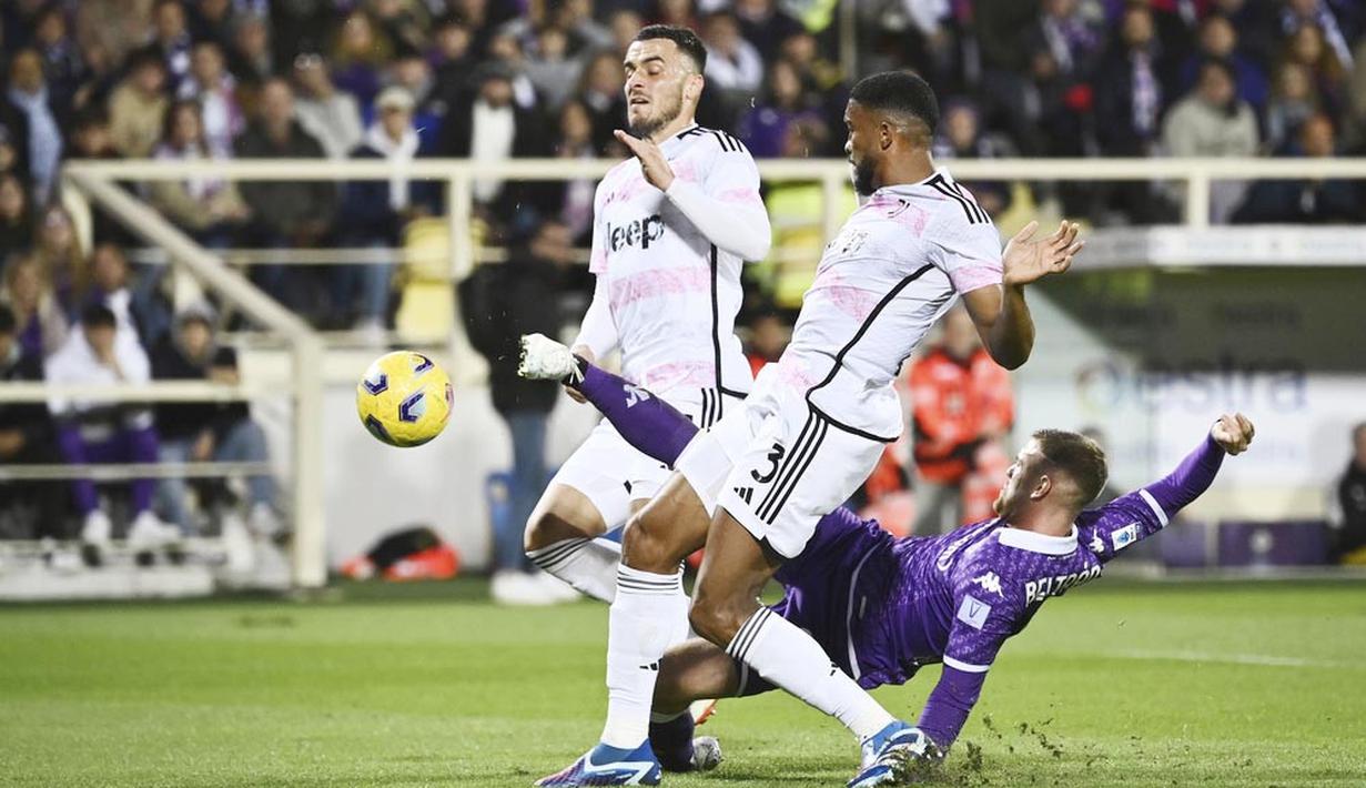 Pemain Juventus, Filip Kostic, berusaha menghalau tendangan pemain Fiorentina, Lucas Beltran, pada laga Liga Italia di Stadion Artemio Franchi, Senin (06/11/2023). (LaPresse via AP/Massimo Paolone)