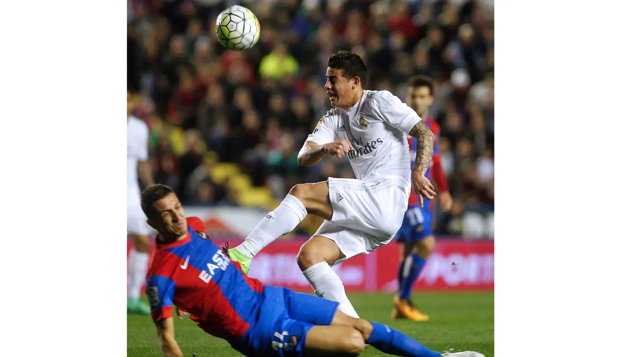 Pemain Levante, Zou Feddal (kiri) menghalangi tembakan pemain Real Madrid, James Rodriguez  pada laga lanjutan La Liga Spanyol; di Stadion Ciutat de Valencia; Kamis (3/3/2016) dini hari WIB. ( AFP/Jose Jordan)