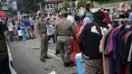 Satpol PP DKI Jakarta menertibkan PKL yang berdagang di kawasan Car Free Day, Bundaran HI, Jakarta, Minggu (20/1). Penertiban dilakukan karena telah membuat ketidaknyamanan bagi para pengunjung CFD yang ingin berolahraga. (Liputan6.com/Faizal Fanani)