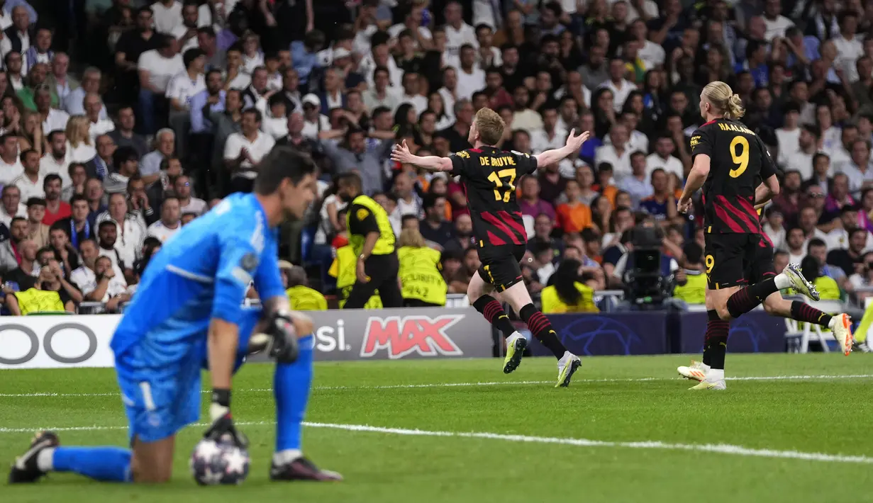 Selebrasi pemain Manchester City, Kevin De Bruyne (tengah), setelah mencetak gol ke gawang kompatriotnya yang bermain untuk Real Madrid, Thibaut Courtois (kiri), dalam pertandingan leg pertama Liga Champions 2022/2023 yang berlangsung di Santiago Bernabeu stadium, Rabu (10/5/2023) dini hari WIB. (AP Photo/Manu Fernandez)