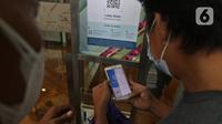 Pengunjung saat scan barcode untuk memasuki mal kuningan city, Jakarta, Selasa (10/8/2021). Perpanjangan PPKM Level 4 di mal pengunjung diwajibkan mematuhi protokol kesehatan, melakukan scan barcode aplikasi Pedulilindungi dan memperlihatkan sertifikat vaksin COVID-19. (Liputan6.com/Herman Zakharia)