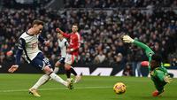 Gelandang Tottenham Hotspur asal Inggris James Maddison (kiri) melepaskan tembakan untuk mencetak gol pembuka melewati kiper Manchester United asal Kamerun Andre Onana (kanan) selama pertandingan sepak bola Liga Primer Inggris antara Tottenham Hotspur dan Manchester United di Stadion Tottenham Hotspur di London, pada 16 Februari 2025.Glyn KIRK / AFP