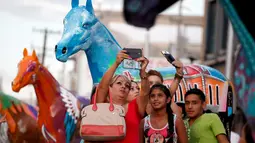  Sejumlah warga asik berselfie didepan patung kuda pusat kota Ciudad Juarez, Meksiko, Selasa (25/8/2015). 20 patung kuda dihias secara unik untuk menarik wisatawan. (REUTERS/Jose Luis Gonzalez)