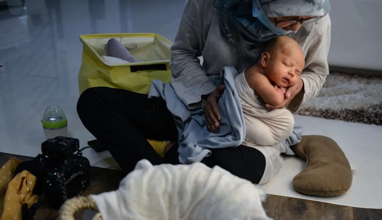 Seorang fotografer wanita, Fanny Nurdiana, saat bekerja selama sesi foto di Banda Aceh pada 18 November 2019. Merekam momen bayi baru lahir lewat fotografi belakangan sedang menjadi tren para orangtua baru di Indonesia. (Photo by CHAIDEER MAHYUDDIN / AFP)