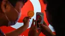 Pelanggan mengambil foto dalgona, permen gula renyah yang ditampilkan dalam serial Netflix Squid Game, di Shanghai pada 12 Oktober 2021. Meski Netflix diblokir pemerintah China, tetapi serial Netflix Squid Game sukses meraih popularitas di Negeri Tirai Bambu itu. (Hector RETAMAL/AFP)