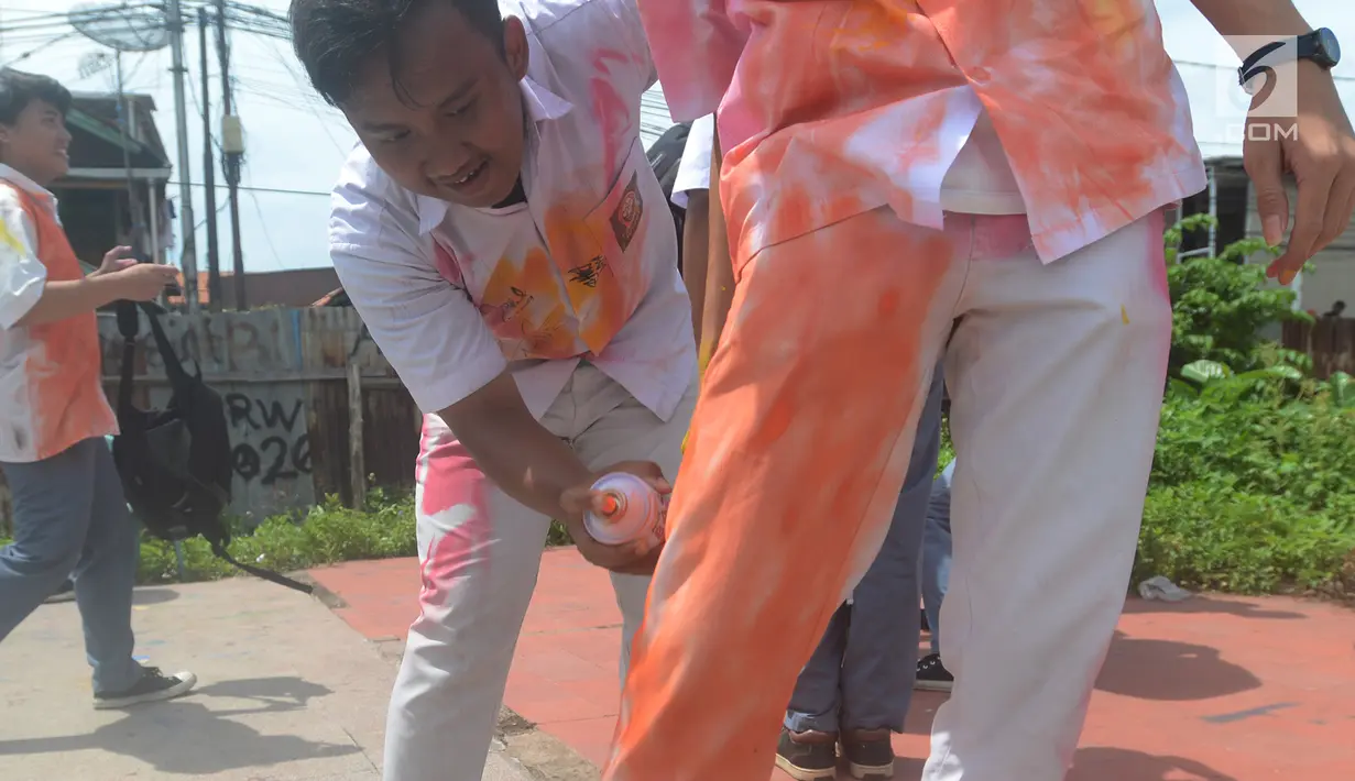 Seorang siswa SMA mencoret seragam rekannya setelah melaksanakan Ujian Nasional Berbasis Komputer (UNBK) di kawasan Cideng, Jakarta, Kamis (12/4). Aksi coret seragam dilakukan siswa sebagai bentuk kegembiraan usai mengikuti UN (Merdeka.com/Imam Buhori)