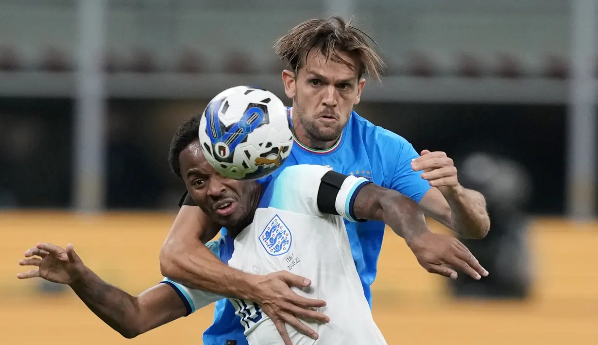 Penyerang Inggris, Raheem Sterling berduel memperebutkan bola dengan pemain Italia, Rafael Toloi selama pertandingan UEFA Nations League di stadion San Siro, di Milan, Italia, Jumat, 23 September 2022. Italia menang tipis atas Inggris 1-0. (AP Photo/Antonio Calanni)