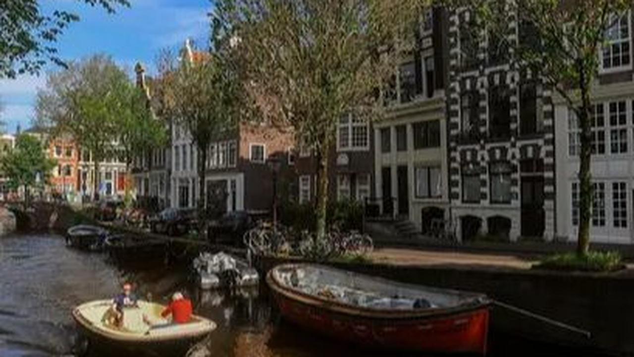 Sebuah kapal berlayar melewati kanal di kota Amsterdam, Belanda, Selasa (22/05/2024).&nbsp;Amsterdam dikenal di seluruh dunia karena kanal-kanalnya yang indah melintasi kota. Merdeka.com/Arie Basuki