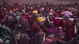 Para Biksu Tibet Menyelimuti dirinya dengan jubah dari cuaca yang dingin saat ikuti Utmost Bliss Dharma di Larung Wuming Buddha Institute, Tibet, Cina (1/11/2015). Tempat ini terletak pada 3700-4000 meter diatas laut. (REUTERS/Damir Sagolj)