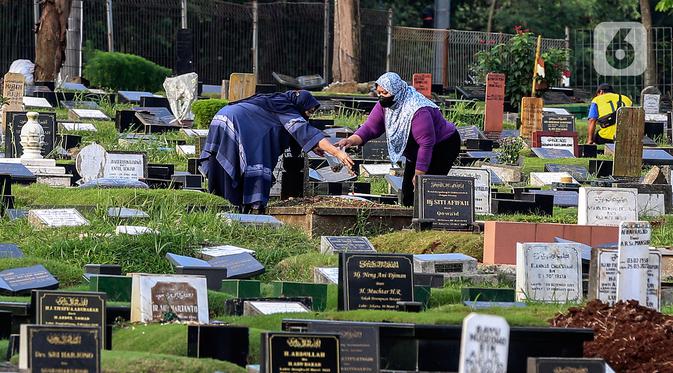 Warga menaburkan bunga di makam keluarganya di Tempat Pemakaman Umum (TPU) Tanah Kusir, Jakarta, Selasa (29/3/2022). TPU setempat semakin banyak dikunjungi warga yang melakukan tradisi ziarah kubur menjelang Ramadhan. (Liputan6.com/Johan Tallo)