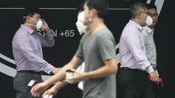 Warga Singapura menggunakan masker saat menjalankan aktivitas Singapura, Selasa (29/9/2015). Badan Lingkungan Hidup Nasional Singapura meningkatkan level kabut asap menjadi sangat tidak sehat (REUTERS/Edgar Su)