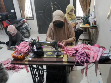 Ibu-ibu PKK membuat masker kain di Desa Bojongkulur, Gunung Putri, Bogor, Jawa Barat, Kamis (9/4/2020). Saat pelaksanaan isolasi mandiri akibat COVID-19 di rumahnya masing-masing, ibu-ibu PKK ini membuat masker untuk dibagikan secara gratis kepada warga sekitar. (merdeka.com/Arie Basuki)
