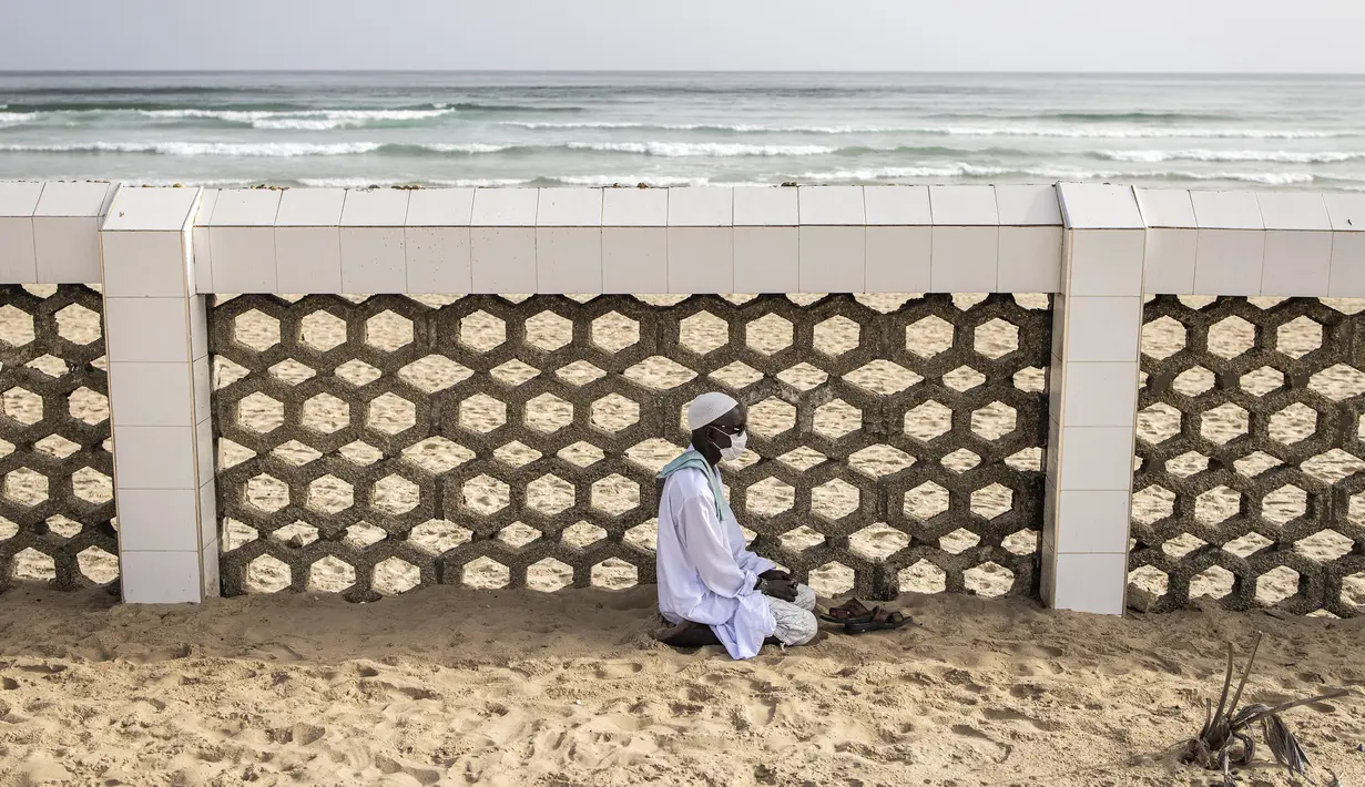 Seorang pengikut komunitas Layene Senegal terlihat selama perayaan Tabaski (Idul Adha) di lingkungan populer Yoff di Dakar, Rabu (21/7/2021). Para jemaah mengenakan pakaian putih untuk merayakan hari raya umat Muslim yang dikenal di Senegal sebagai 'Tabaski'. (JOHN WESSELS / AFP)