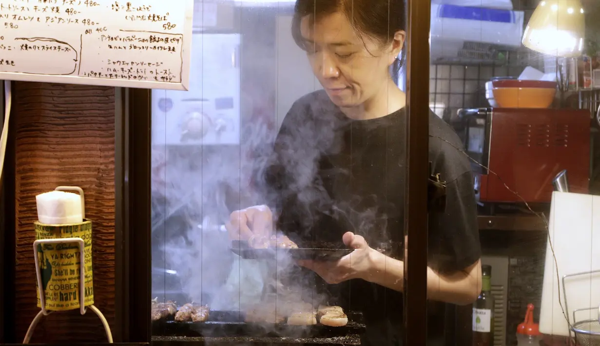 Seorang pemilik bar menyiapkan Yakitori di area jalan malam belakang pusat kota Tokyo (4/10/2019). Yakitori merupakan sate khas dari Jepang yang umumnya menggunakan daging ayam.  (AP Photo/Mark Baker)