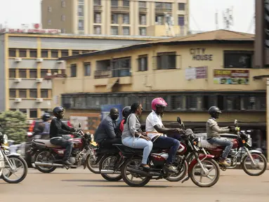 Pengemudi ojek, yang dikenal secara lokal sebagai boda-boda, berkendara bersama penumpang di jalan Kampala, Uganda, pada 18 Juli 2024. (AP Photo/Hajarah Nalwadda)