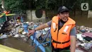 Petugas UPK Badan Air DLH Provinsi DKI Jakarta berjibaku membersihkan tumpukan sampah yang menghalangi aliran air Kali Mampang di Jalan Pejaten Raya, Jakarta, Sabtu (20/2/2021). Aliran air Kali Mapang di Jalan Pejaten Raya meluap akibat sumbatan tumpukan sampah. (Liputan6.com/Helmi Fithriansyah)