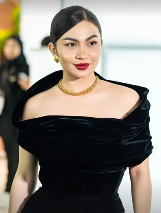 Penampilan Ariel Tatum tak kalah memesona. Ia tampil mengenakan dress  off-the-shoulder berwarna hitam, dipadukan dengan aksesori berupa kalung dan anting-anting emas, tatanan rambut sleek-look, dan pulasan lipstik merah. [Foto: Instagram/irvandyyuliusr]