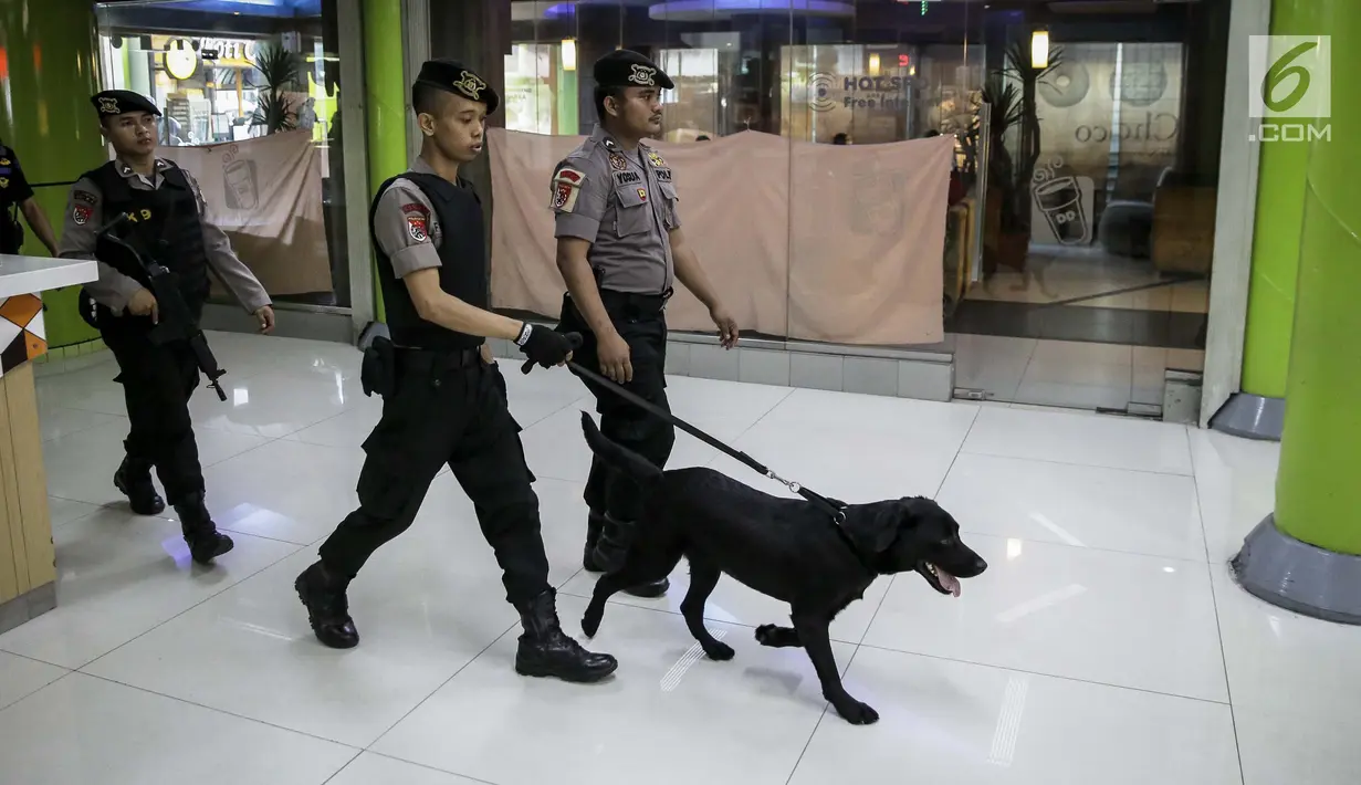 Petugas dan anjing unit k-9 mengecek tempat parkir di kawasan Stasiun Gambir, Jakarta, Kamis (1/6). Hal ini dilakukan sebagai upaya mencegah hal yang tidak diinginkan pasca bom Terminal Kampung Melayu. (Liputan6.com/Faizal Fanani)