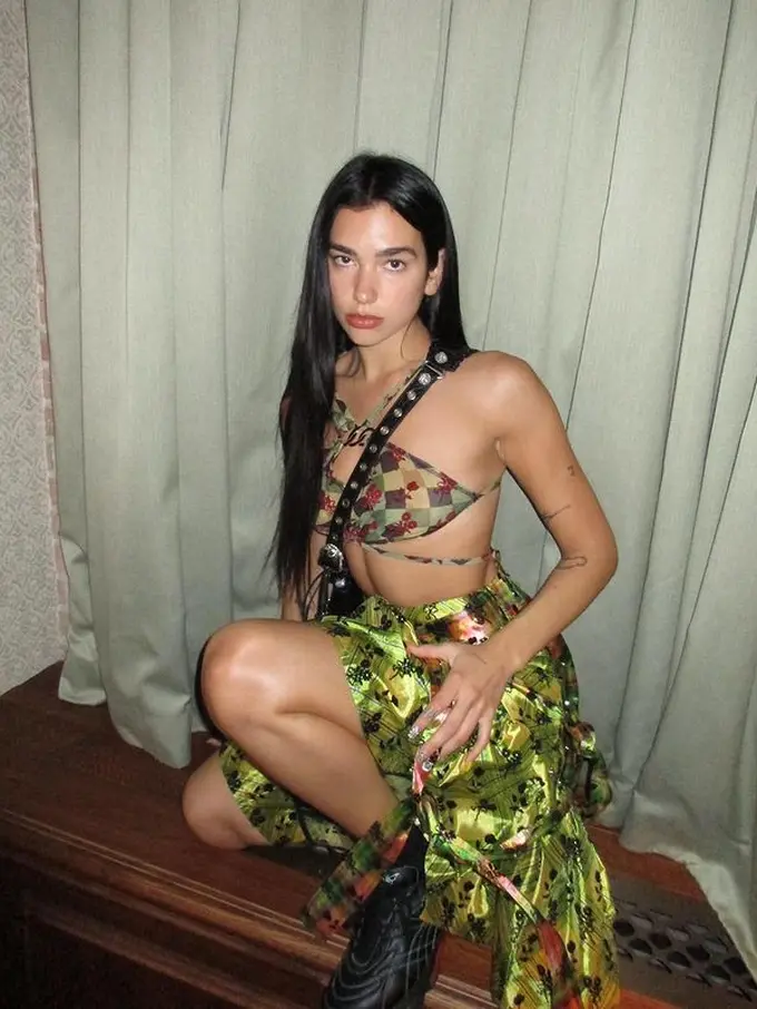 Potret Dua Lipa dengan Rok Unik Tampilkan Look Punk di Era 90an
