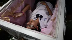 Seorang siswa remaja berbaring di dalam peti mati di Kid Mai Death Awareness Cafe, Thailand (30/3). Cafe ini menyediakan ruang pameran yang dibangun untuk mendidik masyarakat tentang kematian dan agama Buddha di Bangkok. (AFP/Lillian Suwanrumpha)