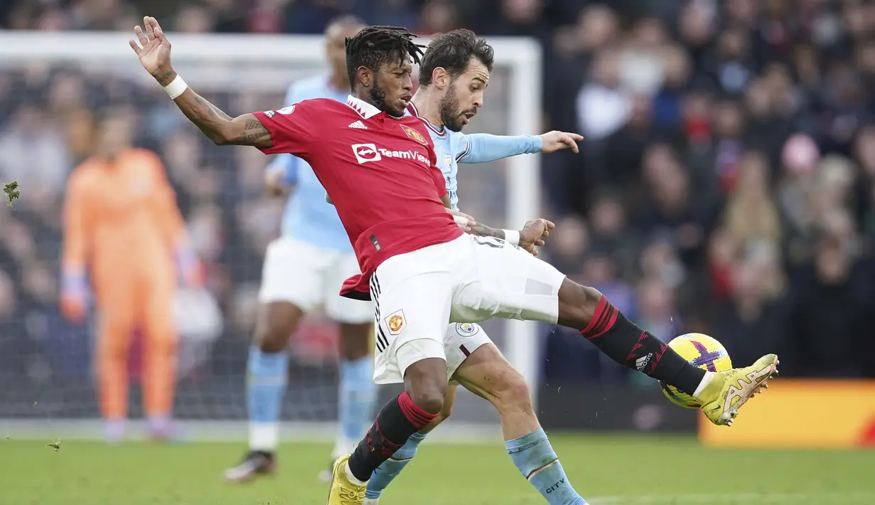 Pemain Manchester United, Fred, berebut bola dengan pemain Manchester City, Bernardo Silva pada laga Liga Inggris di Stadion Old Trafford (17/1/2023). Penampilan Fred semakin gemilang terutama saat MU membungkam rival Manchester City beberapa waktu lalu. (AP Photo/Dave Thompson)