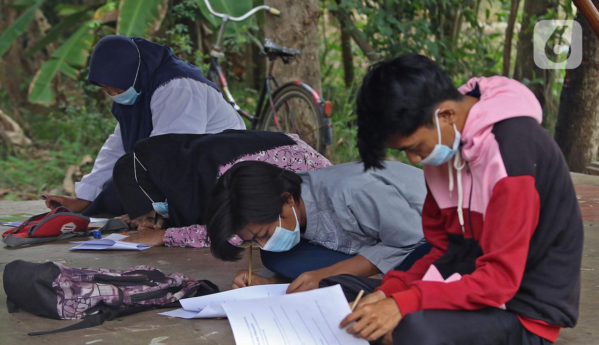 Para murid SMP Sekolah Alam mengisi soal Ujian Akhir Semester (UAS) di Sukawangi, Kabuapaten Bekasi, Jawa Barat, Senin (30/11/2020). Menurut pengurus Sekolah Alam KBM tatap muka  jenjang pendidikan SD,SMP, dan SMA tetap berjalan dengan menerapkan protokol kesehatan. (Liputan6.com/Herman Zakharia)