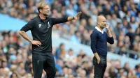 Pelatih Liverpool Juergen Klopp (kiri) dan disebelahnya pelatih Manchester City Pep Guardiola memberi arahan kepada timnya saat pertandingan Liga Inggris di Stadion Etihad, Manchester (9/9). (AP Photo/Rui Vieira)