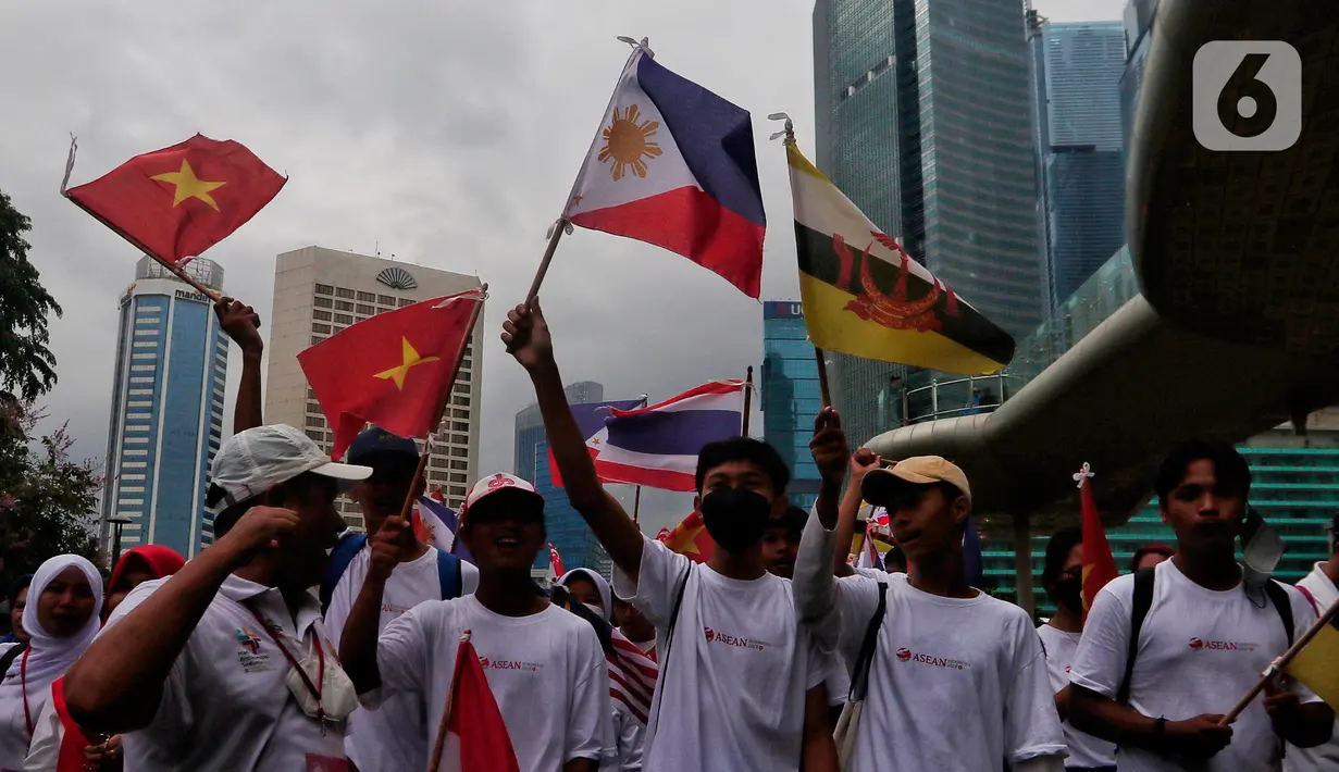 Peserta parade membawa bendera anggota ASEAN saat berjalan dalam Parade Asean di Jalan MH. Thamrin, Jakarta, Minggu (29/1/2023). Acara tersebut merupakan 'kick off' keketuaan Indonesia dalam ASEAN 2023 yang puncaknya akan berlangsung dua kali, yakni Konferensi Tingkat Tinggi (KTT) ASEAN pada Mei 2023 di Labuan Bajo, Provinsi Nusa Tenggara Timur (NTT) dan KTT ASEAN Plus di Jakarta pada September 2023. (Liputan6.com/Angga Yuniar)