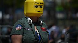 Seorang cosplayer mengenakan jaket Top Gun dan kepala lego berjalan di luar pusat konvensi selama San Diego Comic Con International 2022 di San Diego, California (22/7/2022). San Diego Comic Con 2022 berlangsung selama empat hari ini dari 21-24 Juli. (AFP Photo/Robyn Beck)