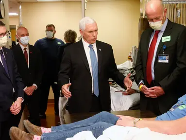 Wakil Presiden AS, Mike Pence berbincang dengan mantan pasien corona yang menyumbangkan darahnya, Dennis Nelson, saat mengunjungi Mayo Clinic di Minnesota, Selasa (28/4/2020). Pence terlihat tanpa masker, meskipun ada aturan internal rumah sakit mewajibkan pengunjung untuk bermasker. (AP/Jim Mone)