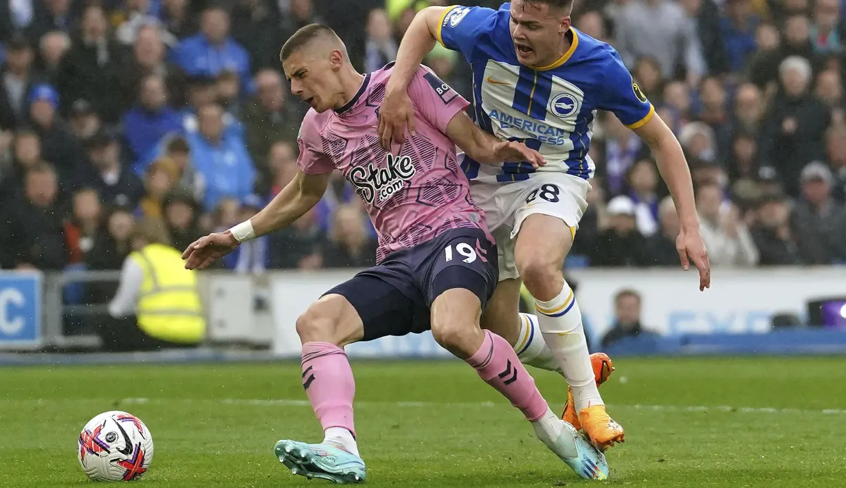 Pemain Everton, Vitaliy Mykolenko (kiri) berebut bola dengan pemain Brighton, Evan pada laga pekan ke-35 Liga Inggris 2022/2023 di  American Express Community Stadium, Brighton, Inggris, Selasa (09/05/2023) WIB. The Toffees menang dengan skor 5-1. (AP Photo/PA/Adam Davy)