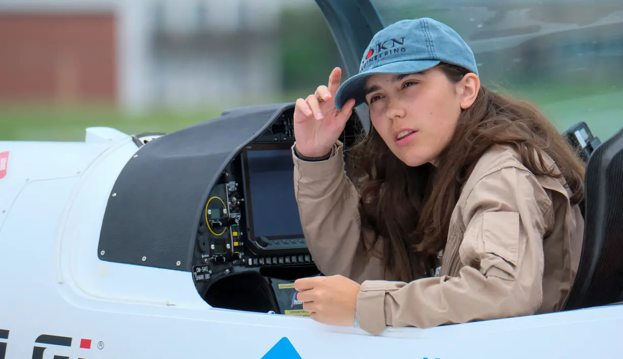 Pilot Zara Rutherford duduk di kokpit pesawat Shark Ultralight-nya di lapangan terbang Kortrijk-Wevelgem, Belgia, Rabu (18/8/2021). Zara ingin memecahkan rekor yang dibuat penerbang AS Shaesta Waiz, yang menetapkan patokan dunia pada usia 30 pada tahun 2017. (Icolas Maeterlinck/Belgia/AFP)