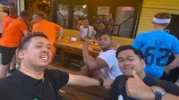 Bola.com berfoto bersama mahasiswa Indonesia di Dortmund, Amirshah Muhammad Ghifary, dan tiga turis Belanda keturunan Maluku ketika berada di fan zone Friedensplatz, Dortmund, Selasa (9/7/2024). (Bola.com/Benediktus Gerendo Pradigdo)