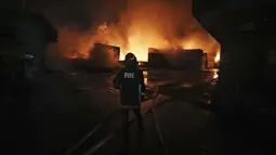 Seorang petugas pemadam kebakaran bekerja untuk memadamkan api yang berkobar di BM Inland Container Depot, sebuah perusahaan patungan Belanda-Bangladesh, di Chittagong, 216 kilometer (134 mil) tenggara ibukota, Dhaka, Bangladesh, Minggu pagi (5/6/2022). kebakaran di BM Inland Container Depot ini dimulai pada Sabtu (4/6) tengah malam waktu setempat. (AP Photo)