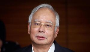 Ekspresi eks PM Malaysia Najib Razak saat tiba di Kantor Komisi Anti-Korupsi Malaysia (MACC) di Putrajaya, Kamis (24/5). Najib diperiksa terkait penyelidikan korupsi miliaran dolar atas dana 1Malaysia Development Berhad (1MDB). (AP Photo/Vincent Thian)