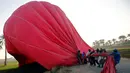 Para kru berusaha menarik balon udara yang mendarat darurat di kota Luxor, Kairo, Mesir (13/12). Dahulu Kota Luxor merupakan pusat pemerintahan Firaun di Mesir dan kini menjadi tempat destinasi wisata. (Reuters/Amr Abdallah Dalsh)