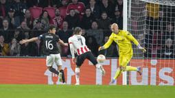 Kiper Sevilla, Marko Dmitrovic berhasil mengamankan bola dari ancaman pemain PSV, Xavi Simons dalam laga leg kedua babak playoff fase gugur Liga Europa 2022/2023 di Philips Stadium, Eindhoven, Jumat (24/2/2023). (AP Photo/Peter Dejong)
